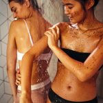 two girls showering with cacao coffee scrub