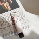 frank body lip balm resting on newspaper in the morning