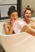 three girls sitting in a bathtub with balloons